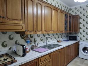 a kitchen with wooden cabinets and a sink at Casa Mimma in Naro +6 photos