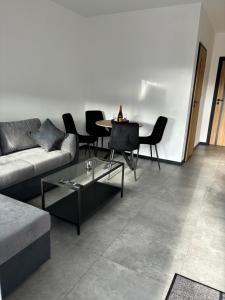 a living room with a couch and a table and chairs at A7 Apartment 3 in Dätgen
