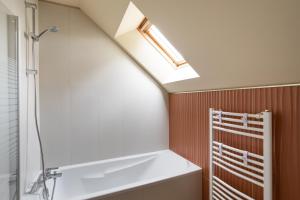 W łazience znajduje się wanna i świetlik. w obiekcie Terra Lodge - maison avec piscine proche plages w mieście Saint-Alban