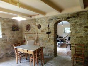 a dining room with a table and a stone wall at La Fonte b&b in Pietralunga