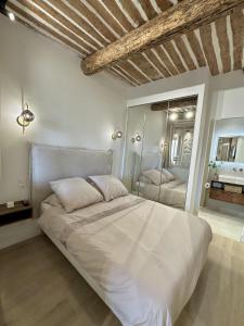 Un dormitorio con una gran cama blanca y un espejo. en New Charming Apartment Old Town, en Antibes