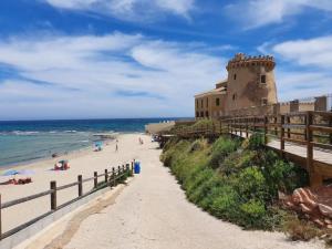 a building on the beach next to the ocean at Sunny Stay in Torre De La Horadada in Torre de la Horadada