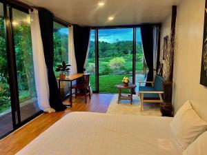 a bedroom with a bed and a large window at River-3Pok in Ban Mae Sapok Noi