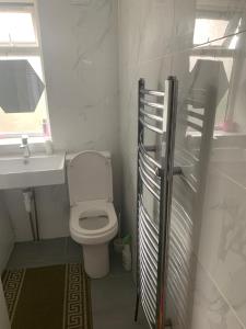 Un baño con inodoro, lavabo y ventana. en At Apex House, en Dagenham