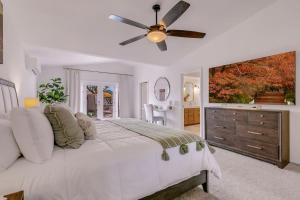 a bedroom with a large bed and a ceiling fan at Happy Hour in Bermuda Dunes +110 photos
