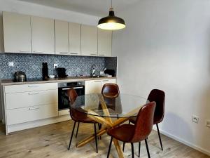 a kitchen with a glass table and some chairs at Apartmány Berlín - Rokytnice nad Jizerou in Rokytnice nad Jizerou