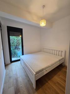 Un dormitorio con una cama en una habitación con ventana. en Zafiro Becici, en Budva
