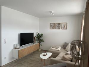 a living room with a couch and a flat screen tv at Das Vechtedomizil - Stilvolle Erdgeschosswohnung mit Sauna, Whirlpool in Nordhorn