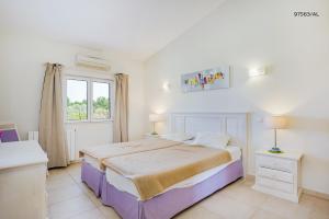 ein weißes Schlafzimmer mit einem Bett und einem Fenster in der Unterkunft Pestana Carvoeiro Golfe - AL in Carvoeiro + 63 Fotos