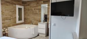 bagno con vasca e TV a parete di studio cosy balneo avec jardin a Le Barcarès