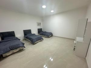 a bedroom with two beds and a tiled floor at نجوم السعد 8 in Al Masfalah