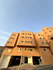 a tall orange building with stairs in front of it at نجوم السعد 8 in Al Masfalah