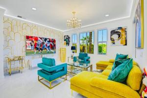 a living room with a yellow couch and blue chairs at Lakeside Luxury in Indio