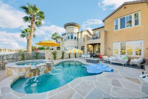 a home with a swimming pool in front of a house at Lakeside Luxury in Indio