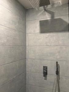 a bathroom with a shower with gray tiles at B&B Casa di Leo in Brindisi +36 photos