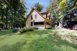 a yellow house with a lawn in front of it at The Mitchell House in North Woodstock