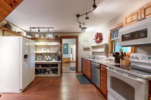 a kitchen with a white refrigerator and wooden floors at The Mitchell House in North Woodstock