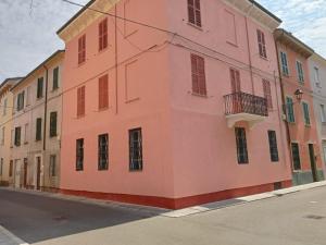 a pink building on the side of a street at Fiore Apartments in Fiorenzuola dʼArda