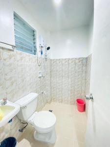 a bathroom with a toilet and a sink at La Pearla Place Boracay Dmall in Boracay