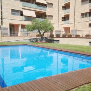 una gran piscina azul frente a un edificio en Calella Can Saula III, en Calella