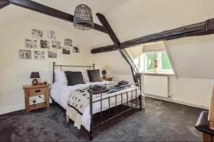 a bedroom with a bed and a window at Holland Cottage in Blockley