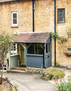 a brick building with a garage in front of it at Holland Cottage in Blockley