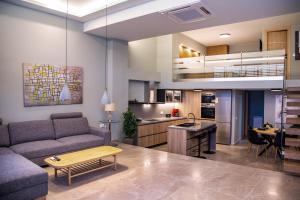 a living room and kitchen with a couch and a table at La Strada executive suite in Sitia