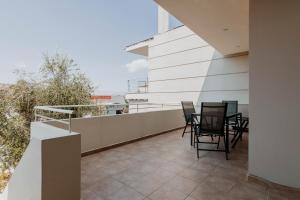 a balcony with black chairs on a white building at Elia House Nafplio in Nafplio