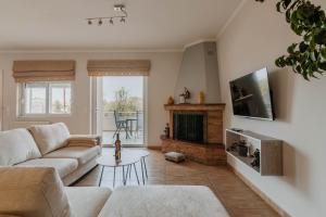 a living room with a couch and a fireplace at Elia House Nafplio in Nafplio