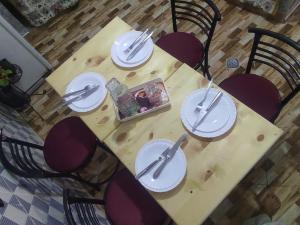 a wooden table with plates and utensils on it at Amina appartement in Azrou