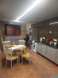 a kitchen with a table and chairs in a room at A ponte in Pontevedra