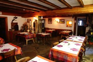 un restaurante con mesas y sillas en una habitación en Auberge du Grammont, en Ramonchamp