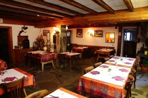 a restaurant with tables and chairs in a room at Auberge du Grammont in Ramonchamp