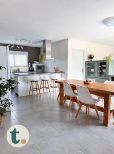 a kitchen and dining room with a table and chairs at Tranquiloue - Maison moderne - Proche PuyduFou in Mesnard-la-Barotière