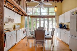 a kitchen with white cabinets and a table and chairs at New Rose Retreat - Pool & Parking in Key West