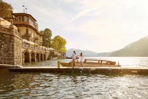 two people standing on a boat on the water at Mandarin Oriental, Lago di Como in Blevio