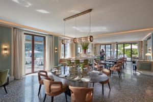 un comedor con mesas, sillas y ventanas en Mandarin Oriental, Lago di Como, en Blevio