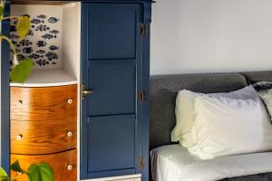 a bedroom with a blue cabinet next to a couch at Au Loup, maison élégante avec arrivée autonome in Waterloo