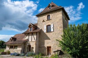 an old stone house with a tower at Atypique maison de charme in Parisot