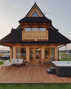 a house with a large deck with a hot tub at Lovelia Luxury Chalet in Zakopane