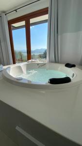 Un baño con bañera y ventana. en Villa Mavi - Praia do Rosa, en Imbituba