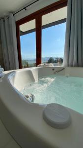 a large bath tub in a room with a window at Villa Mavi - Praia do Rosa in Imbituba +21 photos