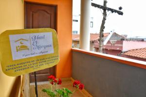 a sign in front of a window with a cross at Hotel el Marqués in Vallegrande