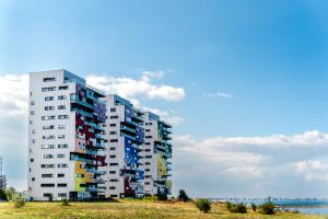 a tall apartment building with colorful windows on the beach at Starshine Spectrum Residence in Constanţa