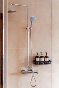 a shower with three bottles on a shelf in a bathroom at Starshine Spectrum Residence in Constanţa +44 photos