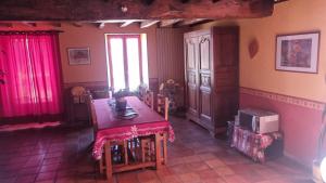 ein Esszimmer mit einem Tisch, Stühlen und einer Mikrowelle in der Unterkunft Chambres d'hôtes entre Niort et Marais Poitevin in Bessines