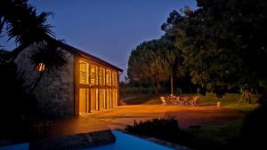 a house with a patio with a table and chairs at QUINTA DO RIBEIRO Garden House in Lousada