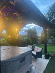 eine Terrasse mit einer Bar und einem Stuhl unter einer Pergola in der Unterkunft The Loft at Rock Cottage with hot tub in Garvagh