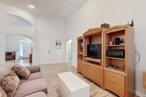ein Wohnzimmer mit Sofa und Entertainment-Center in der Unterkunft Coral Shells in Ocean Pines