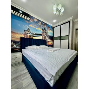 a bedroom with a king sized bed with a painting of the city at Classic Apartment in Tashkent